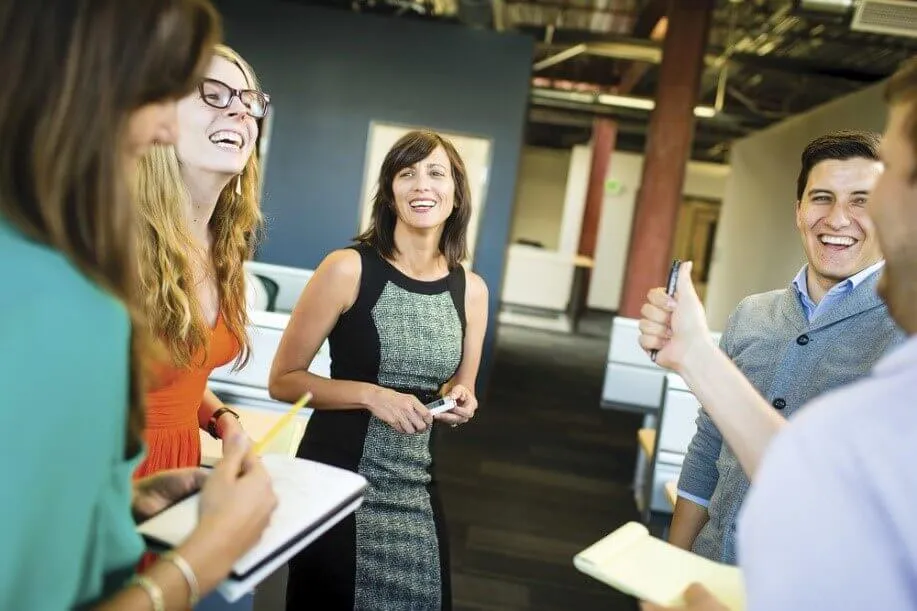 A facilitator laughing with colleagues during a workplace session